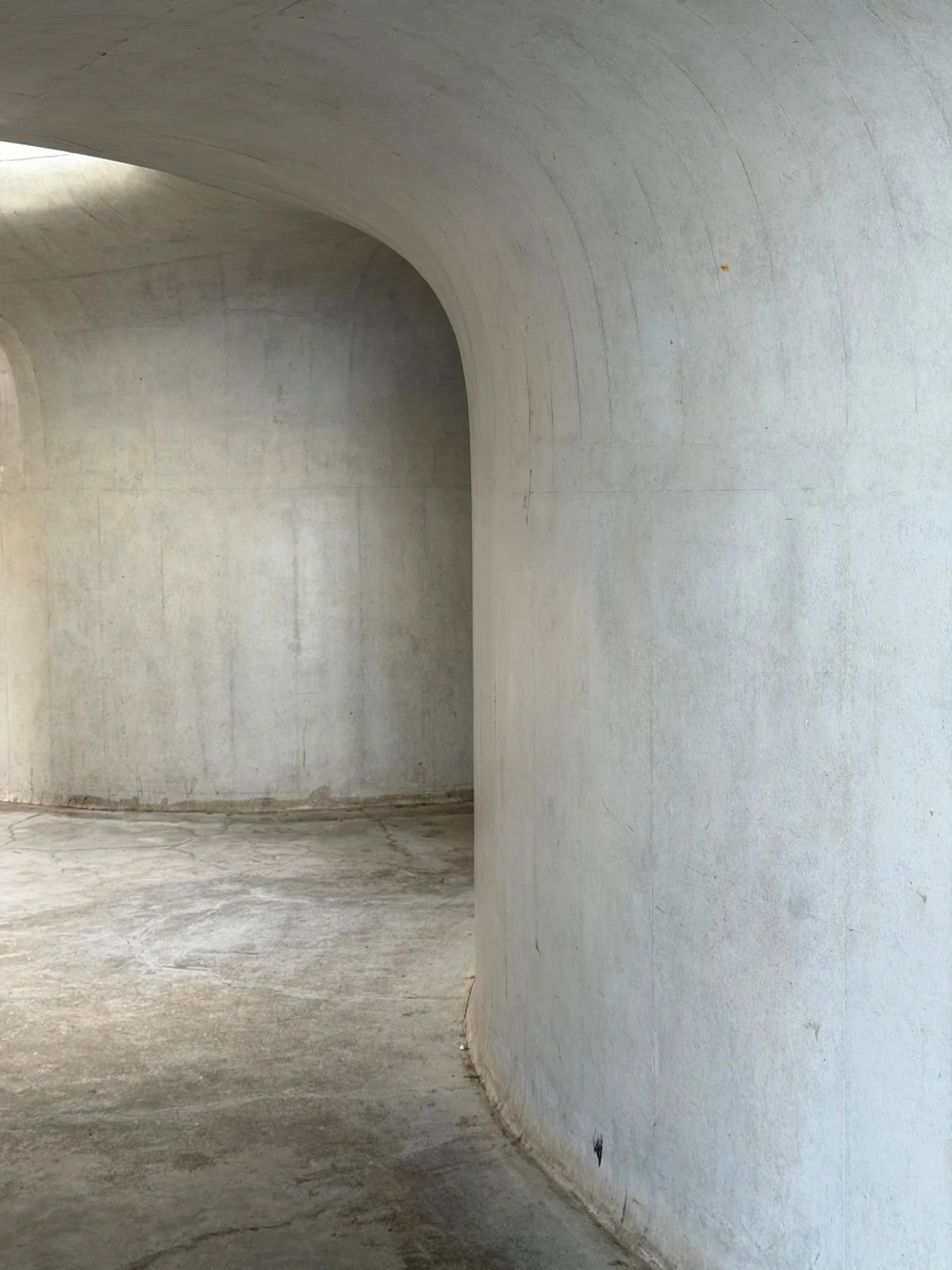 A quiet curved concrete interior, photographed by Yulia Shapereva s