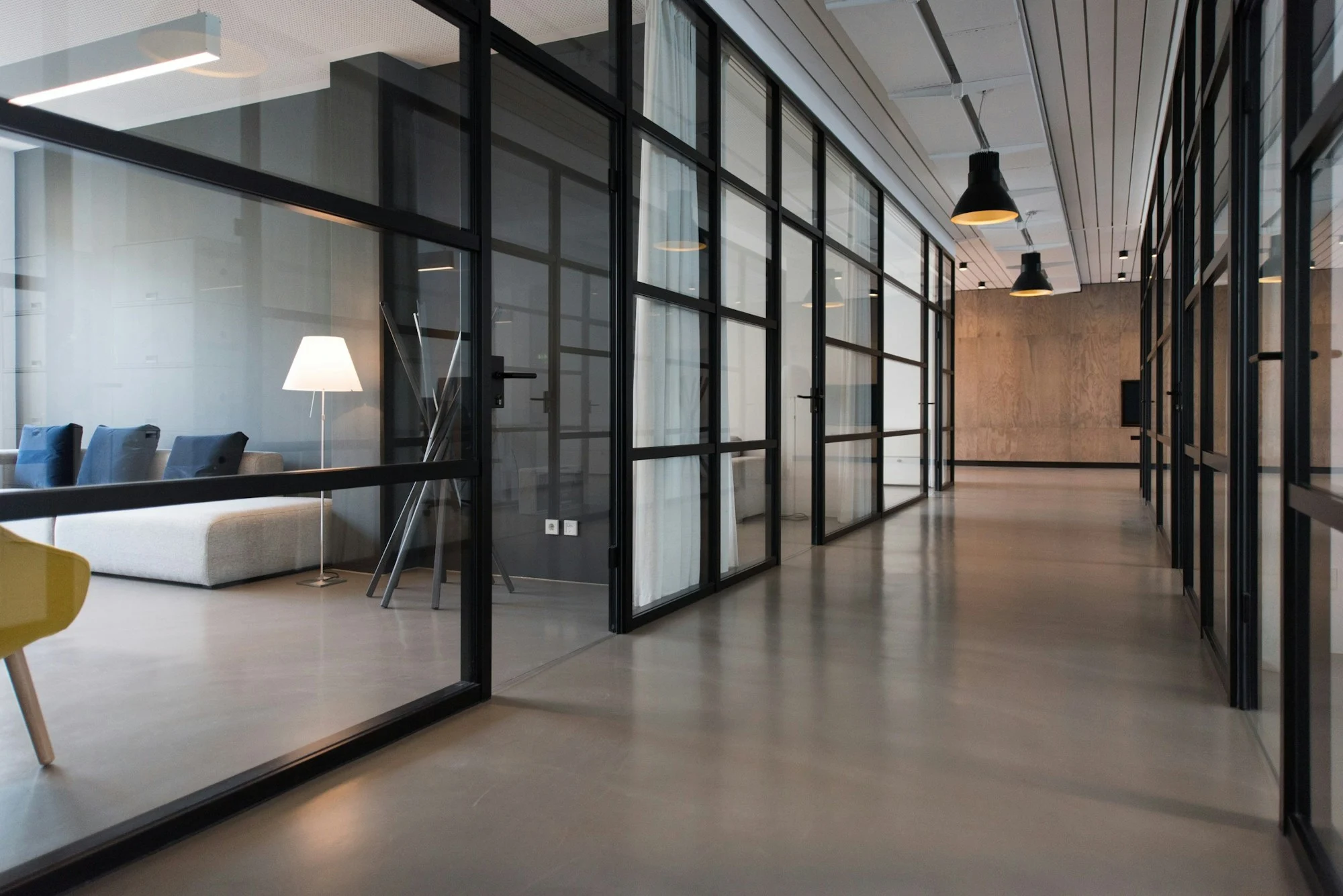 A light-filled workspace with glass partitions and a lounge area